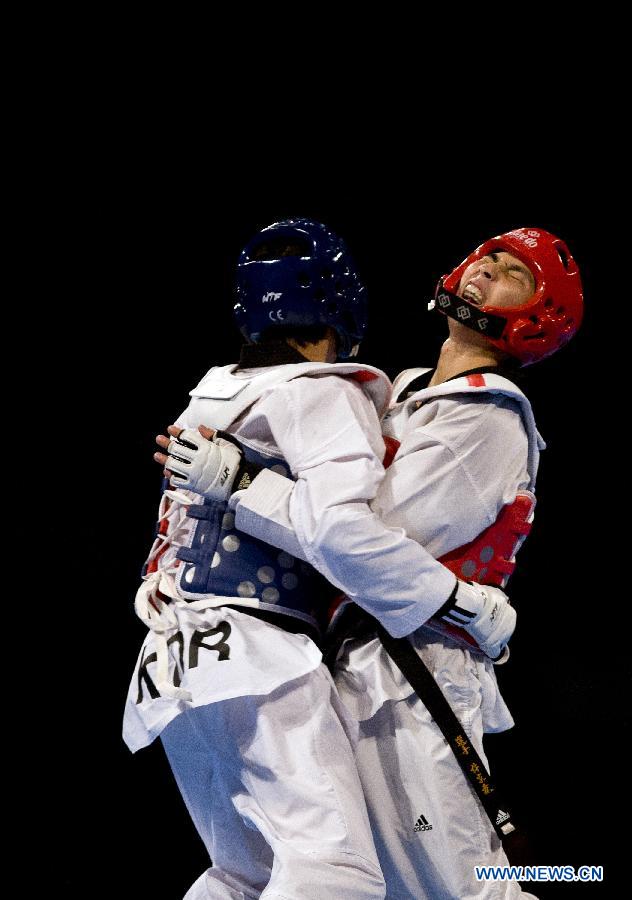 South Korea's Tae-Hun Kim (L) combats against Lin Chia Hsu (R) of Chinese Taipei, during the final of the 54 kg men's category of the Taekwondo World Championship of the World Taekwondo Federation (WTF), at the Expositions and Coventions Center of Puebla, in Puebla, Mexico, on July 18, 2013. (Xinhua/Guillermo Arias)