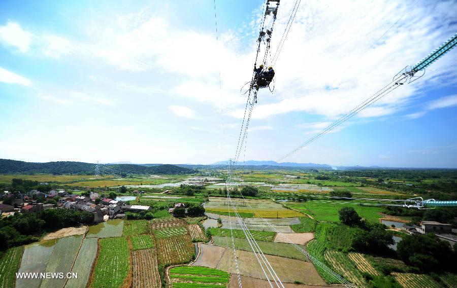 Power grid workers construct a 500kv transmission line at the height of more than 60 meters at Guquan Town in Xuancheng City, east China's Anhui Province, July 18, 2013. (Xinhua/Zheng Xianlie)