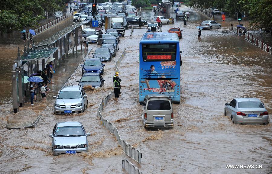 Cars drive on the flooded Jinbi Road in Kunming, capital of southwest China's Yunnan Province, July 19, 2013. Kunming was hit by a heavy rainstorm from Thursday to Friday. Kunming's meteorologic center on Friday issued a blue alert for rainstorm. (Xinhua/Lin Yiguang)
