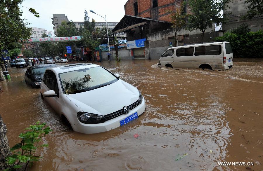 Cars are submerged by flood water on a street in Kunming, capital of southwest China's Yunnan Province, July 19, 2013. Kunming was hit by a heavy rainstorm from Thursday to Friday. (Xinhua/Lin Yiguang)