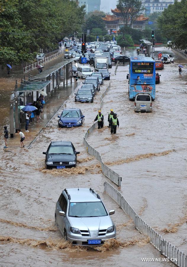 Cars drive on the flooded Jinbi Road in Kunming, capital of southwest China's Yunnan Province, July 19, 2013. Kunming was hit by a heavy rainstorm from Thursday to Friday. Kunming's meteorologic center on Friday issued a blue alert for rainstorm. (Xinhua/Lin Yiguang)