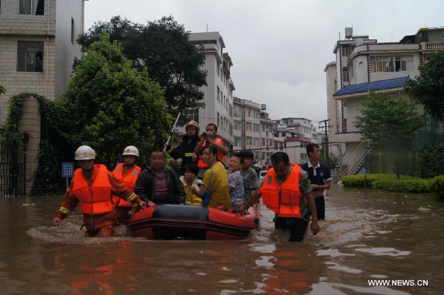 Rescuers evacuate stranded people in Chenjiaying Village of Kunming, capital of southwest China's Yunnan Province, July 19, 2013. Kunming was hit by a heavy rainstorm from Thursday to Friday. Kunming's meteorologic center on Friday issued a blue alert for rainstorm. (Xinhua/Liu Kelin)