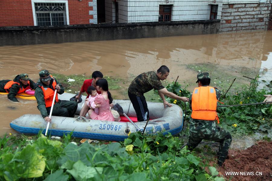 Rescuers evacute locals from the waterlogged Houjing Village at Haicang District in Xiamen, southeast China's Fujian Province, July 19, 2013. Tropical storm Cimaron made landfall in the province Thursday night, bringing rainstorms to Xiamen. Over 40 villagers were evacuated after the low-lying village was flooded. (Xinhua) 