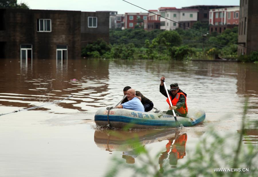 Rescuers evacute a local from the waterlogged Houjing Village at Haicang District in Xiamen, southeast China's Fujian Province, July 19, 2013. Tropical storm Cimaron made landfall in the province Thursday night, bringing rainstorms to Xiamen. Over 40 villagers were evacuated after the low-lying village was flooded. (Xinhua) 