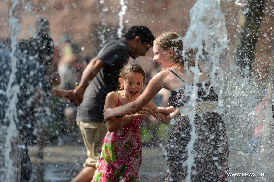 People play in a water fountain during a heatwave in New York of the United States, July 18, 2013. (Xinhua/Wang Lei) 