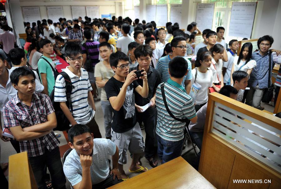 Job hunters attend a job fair in Haikou, south China's Hainan Province, July 19, 2013. Over 6,000 job vacancies from 200 companies were provided at the job fair, attracting more than 8,000 people.(Xinhua/Guo Cheng) 