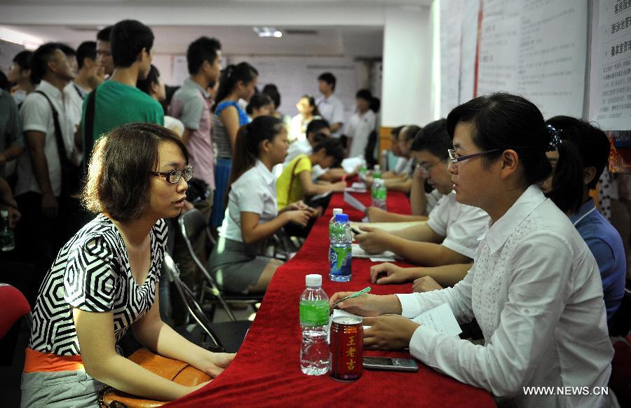 Job hunters attend a job fair held in Haikou, capital of south China's Hainan Province, July 19, 2013. Over 6,000 job vacancies from 200 companies were provided at the job fair, attracting more than 8,000 people.(Xinhua/Guo Cheng)