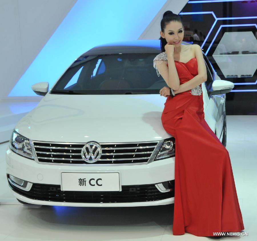 A model poses beside a vehicle at the 5th Huhhot International Auto Exhibition in Huhhot, north China's Inner Mongolia Autonomous Region, July 19, 2013. Some 400 vehicles from more than 70 enterprises and brands were taken to the five-day exhibition which kicked off on Friday. (Xinhua/Liu Yide)