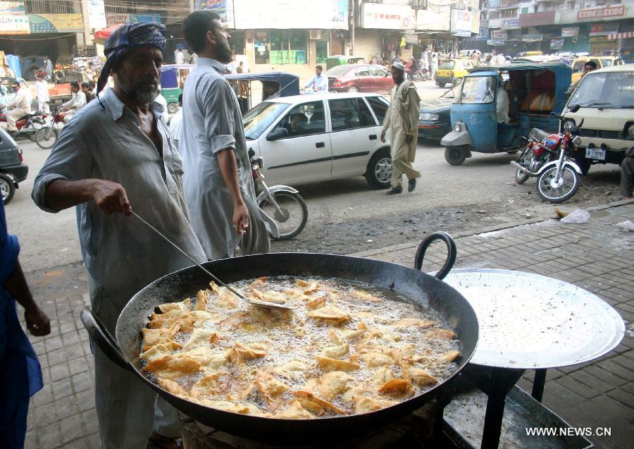 A vendor fries samosa snacks at a stall during the fasting month of Ramadan in northwest Pakistan's Peshawar, July 19, 2013. Muslims around the world refrain from eating, drinking and smoking from dawn to dusk during the fasting month of Ramadan. (Xinhua/Ahmad Sidique)