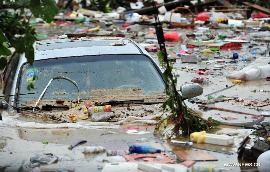 A car is submerged among wastes swept down by mountain torrents and torrential rain in Gangwei Township in Longhai of Zhangzhou City, southeast China's Fujian Province, July 19, 2013. Tropical storm Cimaron made its landfall in Fujian Thursday evening, bringing heavy rain and strong gales to southern part of the province. Xiamen, Zhangzhou, Quanzhou and Putian were severely affected by the storm, with the rainfall in some regions like Longhai reaching 520 millimeters on Friday. About 123,000 residents were afflicted by the storm and no casualties have been reported yet. (Xinhua/Wei Peiquan) 