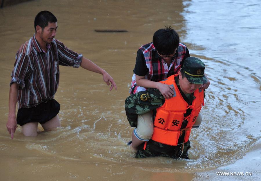 An rescuer transfers a college student who has an acute disease to safety zone in Zhangzhou City, southeast China's Fujian Province, July 19, 2013. Tropical storm Cimaron made its landfall in Fujian Thursday evening, bringing heavy rain and strong gales to southern part of the province. Xiamen, Zhangzhou, Quanzhou and Putian were severely affected by the storm, with the rainfall in some regions like Longhai reaching 520 millimeters on Friday. About 123,000 residents were afflicted by the storm and no casualties have been reported yet. (Xinhua/Wei Peiquan) 
