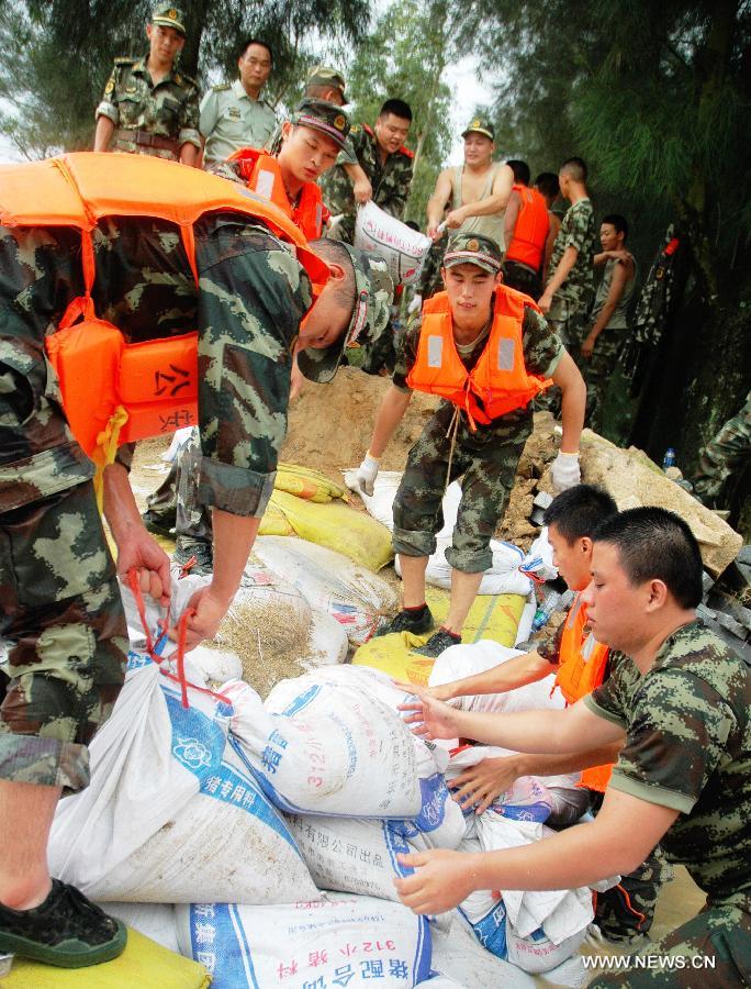 Soldiers caulk a breach of a sea wall with sand bags in Fotan Township of Zhangpu County in Zhangzhou City, southeast China's Fujian Province, July 19, 2013. Tropical storm Cimaron made its landfall in Fujian Thursday evening, bringing heavy rain and strong gales to southern part of the province. Xiamen, Zhangzhou, Quanzhou and Putian were severely affected by the storm, with the rainfall in some regions like Longhai reaching 520 millimeters on Friday. About 123,000 residents were afflicted by the storm and no casualties have been reported yet. (Xinhua/Wei Peiquan) 