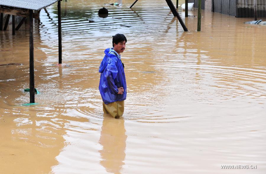 A man standing in water looks at his flooded house in Gangwei Township in Longhai of Zhangzhou City, southeast China's Fujian Province, July 19, 2013. Tropical storm Cimaron made its landfall in Fujian Thursday evening, bringing heavy rain and strong gales to southern part of the province. Xiamen, Zhangzhou, Quanzhou and Putian were severely affected by the storm, with the rainfall in some regions like Longhai reaching 520 millimeters on Friday. About 123,000 residents were afflicted by the storm and no casualties have been reported yet. (Xinhua/Wei Peiquan) 