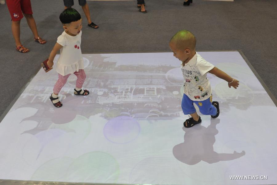 Children play at the first China Ecological Products (Technologies) Expo in Guiyang, capital of southwest China's Guizhou Province, July 19, 2013. The five-day expo, a key part of the 2013 Eco-Forum Global Annual Conference, kicked off here Friday. More than 260 exhibitors will attend the expo to introduce their advanced concepts and techniques in the filed of ecology. (Xinhua/Ou Dongqu)