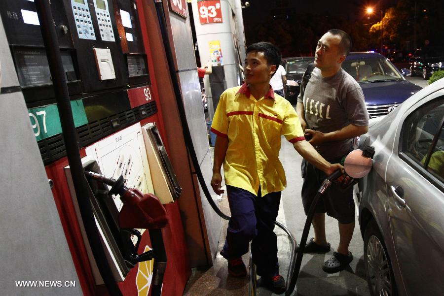 A car owner has his car fueled in a gas station in Shanghai, east China, July 19, 2013. The retail prices of gasoline and diesel of China are raised starting Saturday. The benchmark retail price of gasoline is raised by 0.24 yuan per liter and diesel by 0.26 yuan per liter. (Xinhua/Pei Xin)
