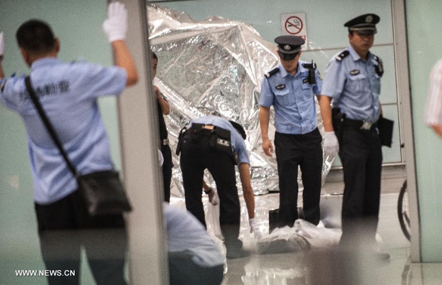Policemen clear site of an explosion at Terminal 3 of the Beijing Capital International Airport in Beijing, capital of China, July 20, 2013. Ji Zhongxing, a 34-year-old from Heze City of east China's Shandong Province, set off a home-made explosive device outside the arrivals exit of the Terminal 3 at around 6:24 p.m. Saturday after he was stopped from handing out leaflets to get attention to his complaints, an initial police investigation showed. Ji suffered no life-threatening injuries and no other injuries were caused. The police cordon at the arrivals exit has been removed, and the airport has begun to resume normal order. (Xinhua/Zhang Yu)