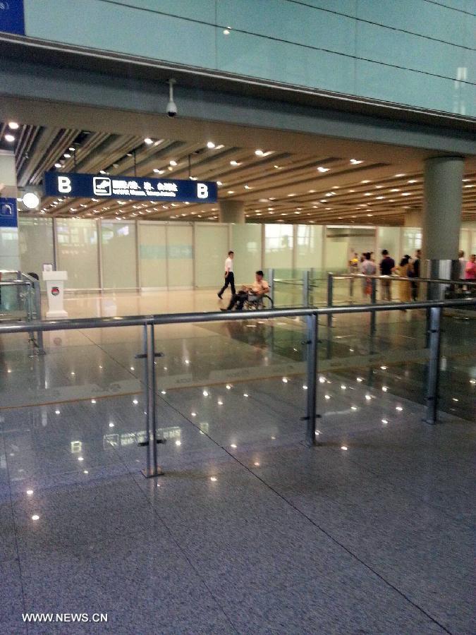 Photo taken on July 20, 2013 with a cellphone shows Ji Zhongxing (man on the wheelchair), suspect of an explosion at Terminal 3 of the Beijing Capital International Airport in Beijing, capital of China. Ji, a 34-year-old from Heze City of east China's Shandong Province, set off a home-made explosive device outside the arrivals exit of the Terminal 3 at around 6:24 p.m. Saturday after he was stopped from handing out leaflets to get attention to his complaints, an initial police investigation showed. Ji suffered no life-threatening injuries and no other injuries were caused. The police cordon at the arrivals exit has been removed, and the airport has begun to resume normal order. (Xinhua) 