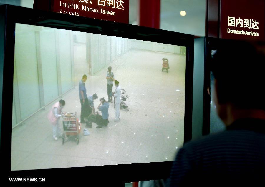 A man watches the closed-circuit television system broadcasting an explosion in T3 terminal at the Beijing Capital International Airport in Beijing, capital of China, July 20, 2013. The explosion occured around 6:24 p.m. on Saturday near the B exit of the terminal. According to eyewitnesses, a disabled person ignited bombs on himself. The casualty is unknown yet. (Xinhua/Chen Jianli)