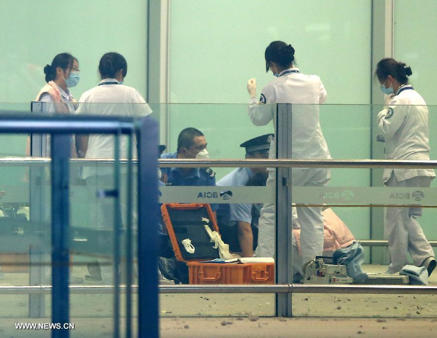 Medical workers and policemen work at an explosion site in T3 terminal of the Beijing Capital International Airport in Beijing, capital of China, July 20, 2013. The explosion occured around 6:24 p.m. on Saturday near the B exit of the terminal. According to eyewitnesses, a disabled person ignited bombs on himself. The casualty is unknown yet. (Xinhua/Chen Jianli)