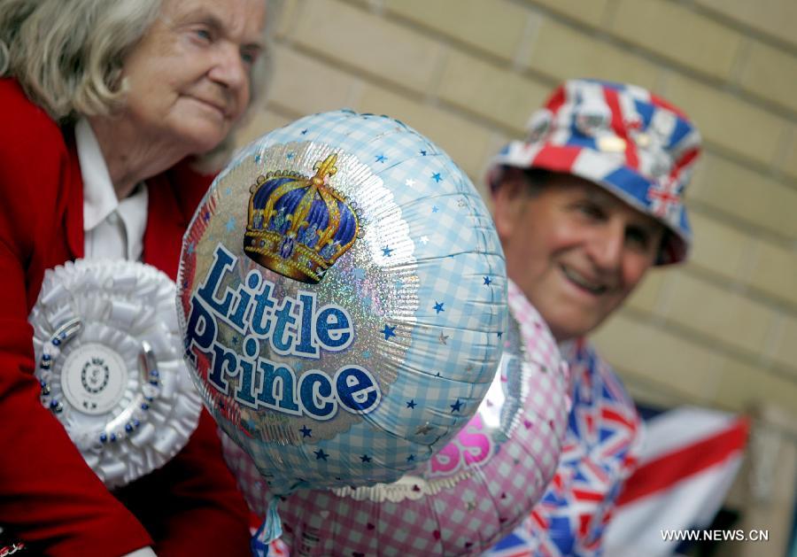 Royal supporters holding little prince and little princess balloons are seen outside the Lindo Wing of St Marys Hospital in London, July 20, 2013. The nation awaits news of a new royal baby. (Xinhua/Bimal Gautam)