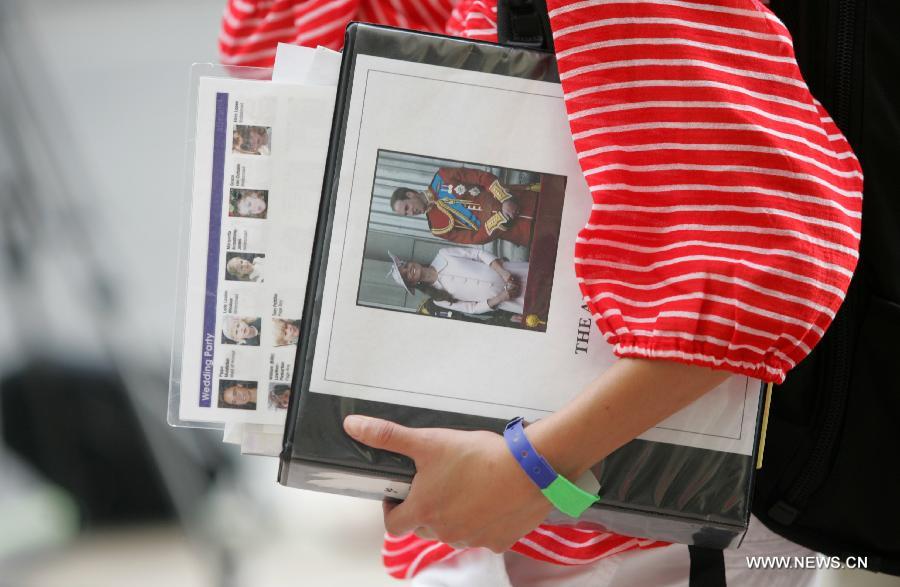 A journalist holds the news documents of the British royal family outside the Lindo Wing of St. Mary's hospital in London, July 20, 2013. The nation awaits news of a new royal baby. (Xinhua/Bimal Gautam) 