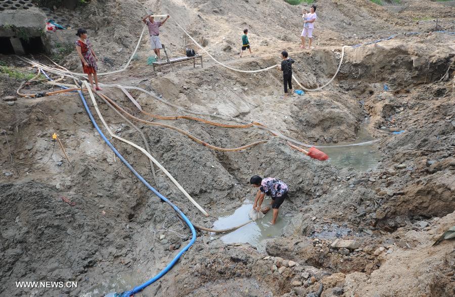 Villagers pump underground water in the Jingzi Township of Shuangfeng County, central China's Hunan Province, July 20, 2013. The drought has left about 283,000 people short of water in Hunan following days of heat, affecting 3.376 million mu (about 225,066 hectares) of croplands. (Xinhua/Nai Jihui)  