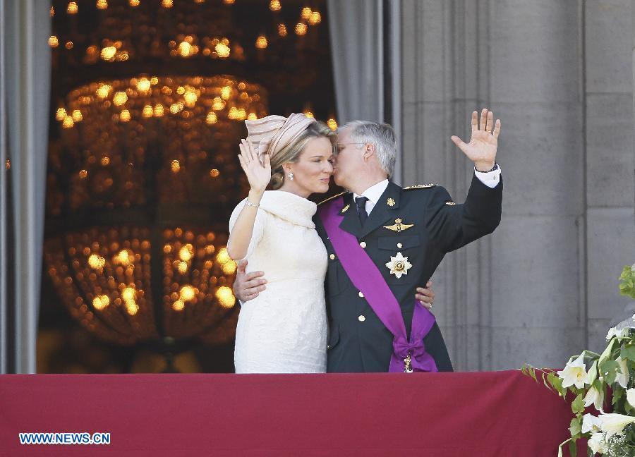 Belgium's newly sworn in King Philippe kisses Queen Mathilde's hand on the balcony of Royal Palace in Brussels, capital of Belgium, on July 21, 2013, the country's national day. Prince Philippe was sworn in before parliament as Belgium's seventh king on Sunday, after his father Albert II abdicated. (Xinhua/Ye Pingfan)