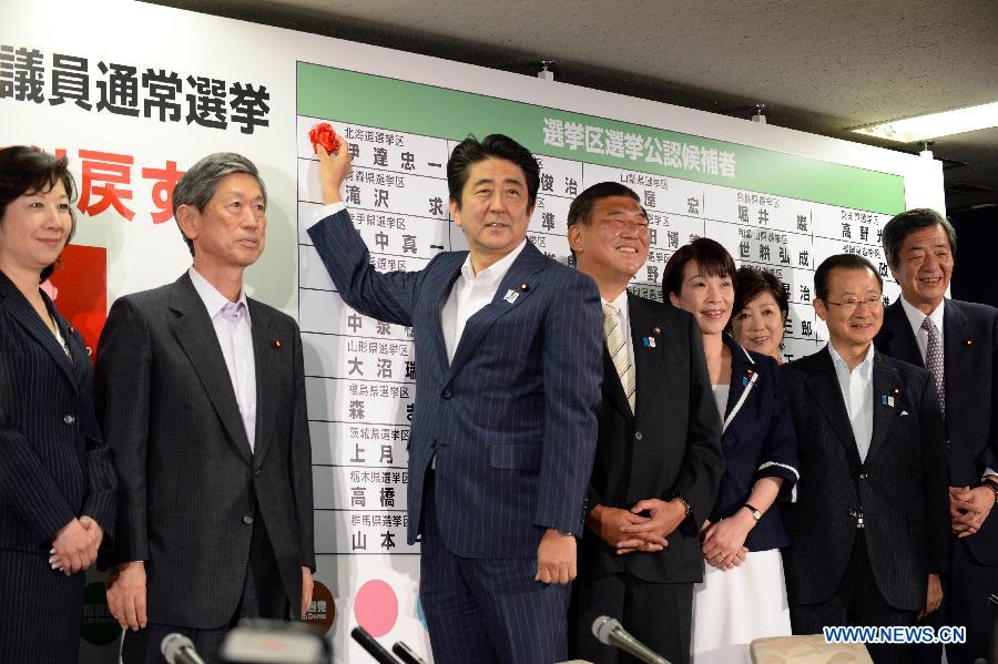 Japanese Prime Minister and President of the Liberal Democratic Party (LDP), Shinzo Abe (3rd L) attaches a red paper rose to a LDP candidate's name to indicate an election victory at the party's headquarters in Tokyo, capital of Japan, July 21, 2013. Japan's ruling camp, the Liberal Democratic Party (LDP) and the New Komeito Party, has put an end to the country's "twisted Diet" as it won a majority of seats in the House of Councillors, according to Japan's broadcaster NHK.(Xinhua/Ma Ping)