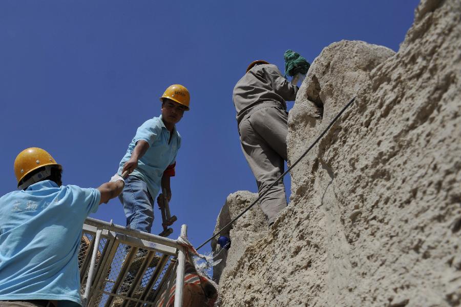 Cultural relics preservation technicists repair walls of the Jiayu Pass, the starting point of a section of the Great Wall constructed during the Ming Dynasty (1368-1644) in Jiayuguan City, northwest China's Gansu Province, July 21, 2013. Built in 1372, the Jiayu Pass also served as a vital passage on the ancient Silk Road. It was listed on UNESCO's World Heritage List in 1987. China has poured 2.03 billion yuan (about 328 million US dollars) in maintaining the Jiayu Pass, also including the construction of a world culture heritage inspection center and a heritage protection and display project at the end of 2011. The local cultural relics bureau announced Sunday that the maintenance project, the largest one since the Pass was set up, has entered the critical stage. (Xinhua/Chen Bin) 