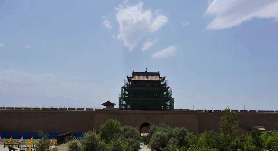 Photo taken on July 21, 2013 shows a gate tower of the Jiayu Pass, the starting point of a section of the Great Wall constructed during the Ming Dynasty (1368-1644), under repair, in Jiayuguan City, northwest China's Gansu Province. Built in 1372, the Jiayu Pass also served as a vital passage on the ancient Silk Road. It was listed on UNESCO's World Heritage List in 1987. China has poured 2.03 billion yuan (about 328 million US dollars) in maintaining the Jiayu Pass, also including the construction of a world culture heritage inspection center and a heritage protection and display project at the end of 2011. The local cultural relics bureau announced Sunday that the maintenance project, the largest one since the Pass was set up, has entered the critical stage. (Xinhua/Chen Bin)