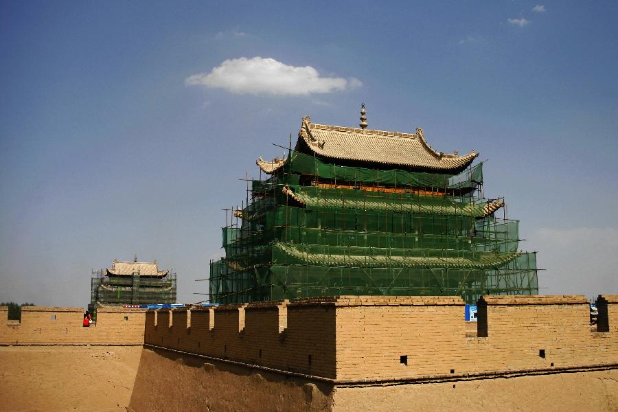 Photo taken on July 21, 2013 shows gate towers of the Jiayu Pass, the starting point of a section of the Great Wall constructed during the Ming Dynasty (1368-1644), under repair, in Jiayuguan City, northwest China's Gansu Province. Built in 1372, the Jiayu Pass also served as a vital passage on the ancient Silk Road. It was listed on UNESCO's World Heritage List in 1987. China has poured 2.03 billion yuan (about 328 million US dollars) in maintaining the Jiayu Pass, also including the construction of a world culture heritage inspection center and a heritage protection and display project at the end of 2011. The local cultural relics bureau announced Sunday that the maintenance project, the largest one since the Pass was set up, has entered the critical stage. (Xinhua/Chen Bin)