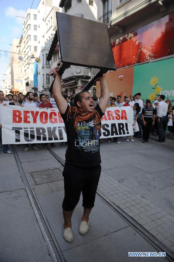 A man carries a table in demonstration in Istanbul on July 21, 2013. Around two thousand people carrying tables and chairs gathered on the Istiklal Avenue, staged a demonstration on Sunday to protest against the municipality's ban on outdoor sitting. The protest marks the second anniversary of the ban on July 21. In 2011 municipality officials removed the street-side tables around Beyoglu's main thoroughfare Istiklal and the upscale Cihangir neighborhood which fueled public outrage. (Xinhua/Lu Zhe) 