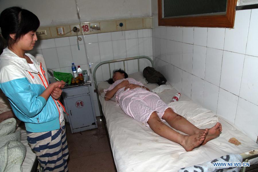 A victim of the landslide in the Jinsixia Gorge receives treatment in a hospital in Shangnan County, northwest China's Shaanxi Province, July 21, 2013. One tourist was killed and 18 others injured by falling rocks at Jinsixia Gorge on Sunday morning. The gorge has been closed temporarily. (Xinhua)