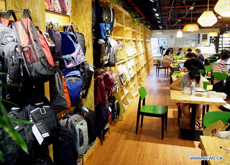 Photo taken on July 21, 2013 shows an entity bookstore on Huaihai Road in east China's Shanghai. Some new style entity bookstores in Shanghai are opened with beverage, food supply and stationery selling. These customer-oriented bookstores bring a new idea for selling books and attract many customers to spend time on reading here. (Xinhua/Chen Fei)
