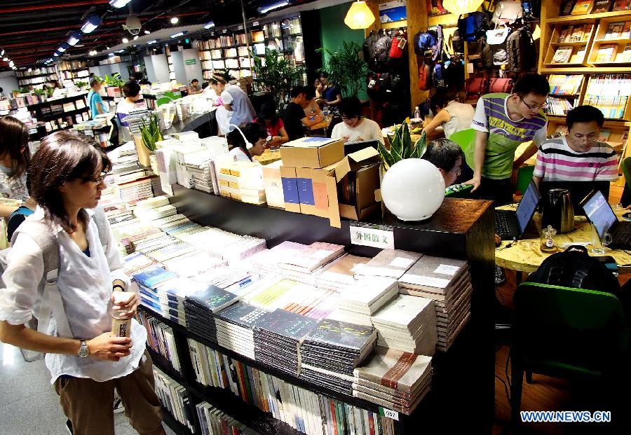 Customer rest and surf the internet in an entity bookstore on Huaihai Road in east China's Shanghai, July 21, 2013. Some new style entity bookstores in Shanghai are opened with beverage, food supply and stationery selling. These customer-oriented bookstores bring a new idea for selling books and attract many customers to spend time on reading here. (Xinhua/Chen Fei)