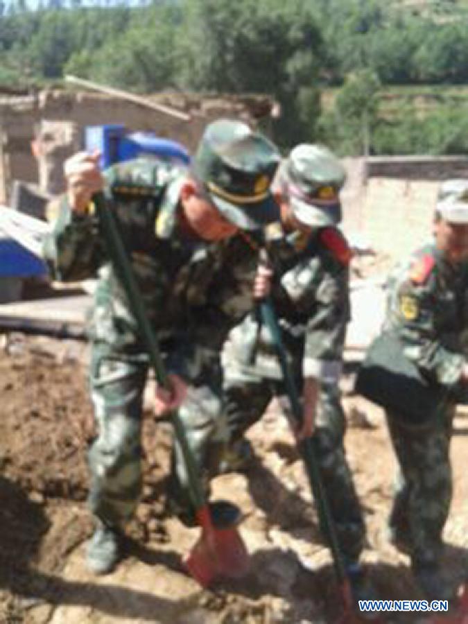 Photo taken with a mobile phone shows rescuers work in quake-hit Meichuan Town of Minxian County, northwest China's Gansu Province, July 22, 2013. A 6.6-magnitude earthquake jolted a juncture region of Minxian County and Zhangxian County in Dingxi City Monday morning. (Xinhua) 