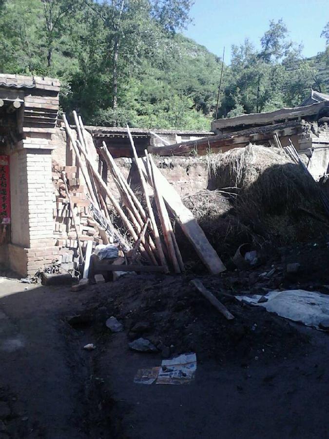 Photo taken with a mobile phone shows a damaged house in quake-hit Meichuan Town of Minxian County, northwest China's Gansu Province, July 22, 2013. At least three people were killed in the 6.6-magnitude earthquake which jolted a juncture region of Minxian County and Zhangxian County in Dingxi City Monday morning. (Xinhua/Kang Yapeng)