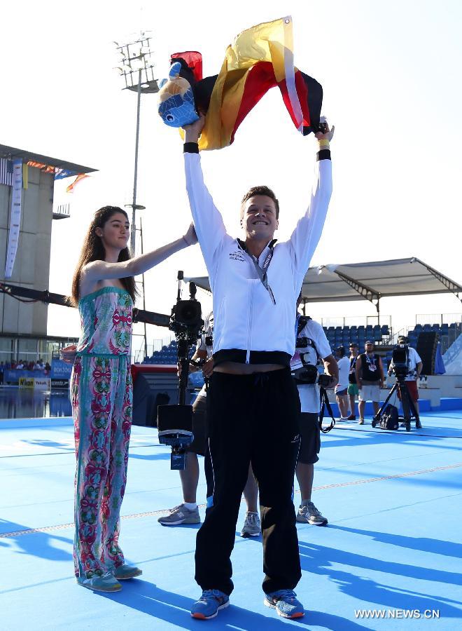 Germany's Patrick Hausding waves German national flag to celebrate winning gold with his partner Sascha Klein after the men's 10m synchro platform final of the Diving competition in the 15th FINA World Championships at the Piscina Municipal de Montjuic in Barcelona, Spain, on July 21, 2013. Sascha Klein and Patrick Hausding claimed the title with a total socre of 461.46 points. (Xinhua/Wang Lili)