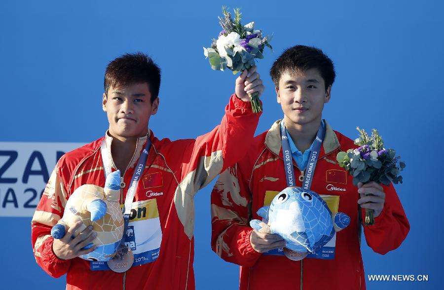 China's Cao Yuan (R) and Zhang Yanquan greet the spectators during the awarding ceremony after the men's 10m synchro platform final of the Diving competition in the 15th FINA World Championships at the Piscina Municipal de Montjuic in Barcelona, Spain, on July 21, 2013. Cao Yuan and Zhang Yanquan took the bronze with a total socre of 445.56 points. (Xinhua/Wang Lili)