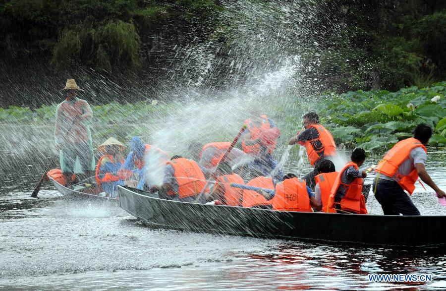 Tourists play at the Puzhehei scenic area in Qiubei County, southwest China's Yunnan Province, July 19, 2013. Known as "the unique pastoral scenery in China", the beauty spot attracts a large number of tourists with 380 mountain peaks, 83 karst caves, 54 lakes and 2,667 hectares of wetlands. (Xinhua/Yang Zongyou)