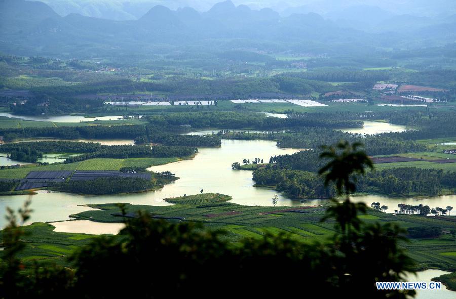 Photo taken on July 20, 2013 shows a view of the Puzhehei scenic area in Qiubei County, southwest China's Yunnan Province. Known as "the unique pastoral scenery in China", the beauty spot attracts a large number of tourists with 380 mountain peaks, 83 karst caves, 54 lakes and 2,667 hectares of wetlands. (Xinhua/He Han)