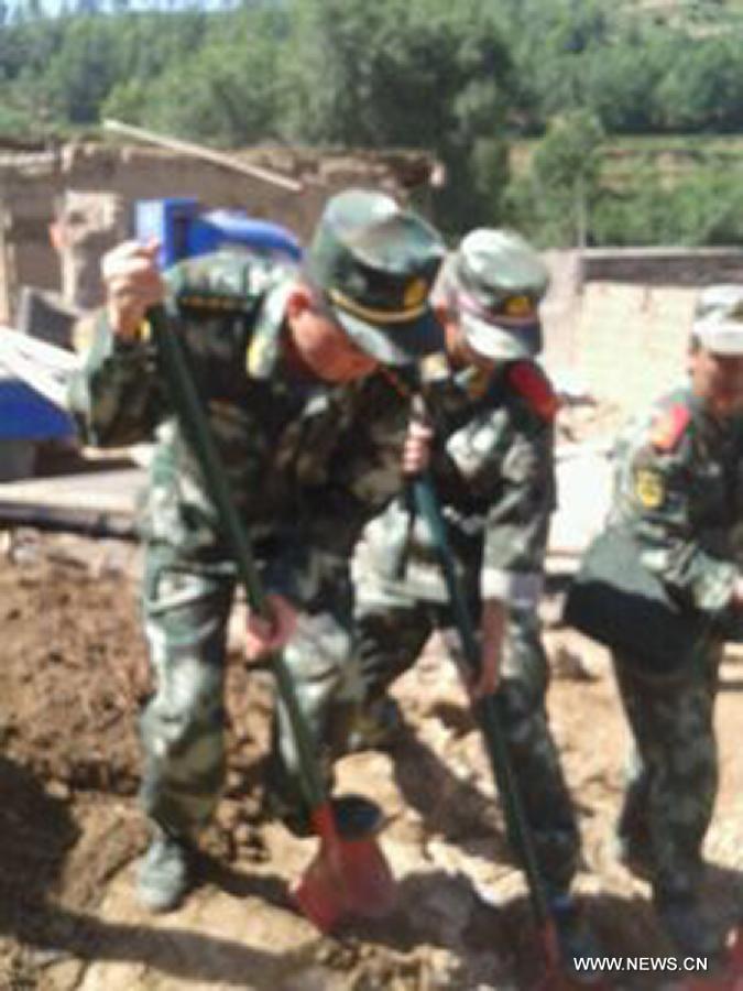 Photo taken with a mobile phone shows rescuers work in quake-hit Meichuan Town of Minxian County, northwest China's Gansu Province, July 22, 2013. A 6.6-magnitude earthquake jolted a juncture region of Minxian County and Zhangxian County in Dingxi City Monday morning. (Xinhua) 