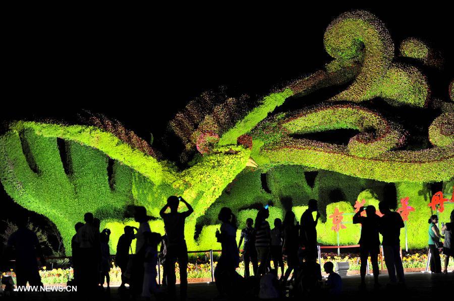 Tourists visit the Garden Expo Park in the evening in Beijing on July 19, 2013. The 9th China (Beijing) International Garden Expo began in Beijing on May 18 and will run until November 18, 2013. [Photo: Xinhua]          