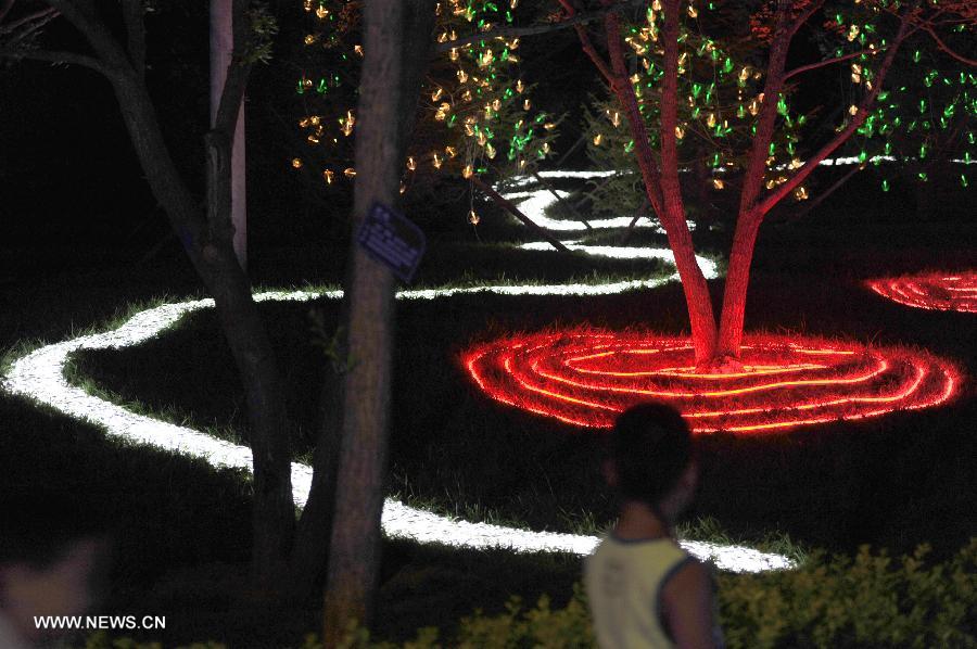 Tourists visit the Garden Expo Park in the evening in Beijing, capital of China, on July 19, 2013. The 9th China (Beijing) International Garden Expo began in Beijing on May 18 and will run until November 18, 2013. [Photo: Xinhua]           