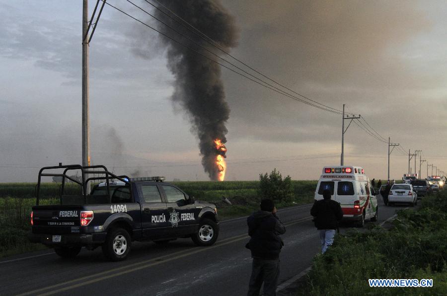 Elements of the Red Cross, firemen and policemen work near the place where a fire was registered in a duct of the Mexican oil company Pemex, in the Tonanitla municipality, in the State of Mexico, Mexico, on July 21, 2013. The oil spill and fire in Tonanitla were caused by a clandestine outlet to extract the fuel, Pemex confirmed in a statement. Until now, the authorities have reported 6 people wounded, two of them belonging to the fire brigade and four municipal policemen. (Xinhua/Juan Carlos Villa)