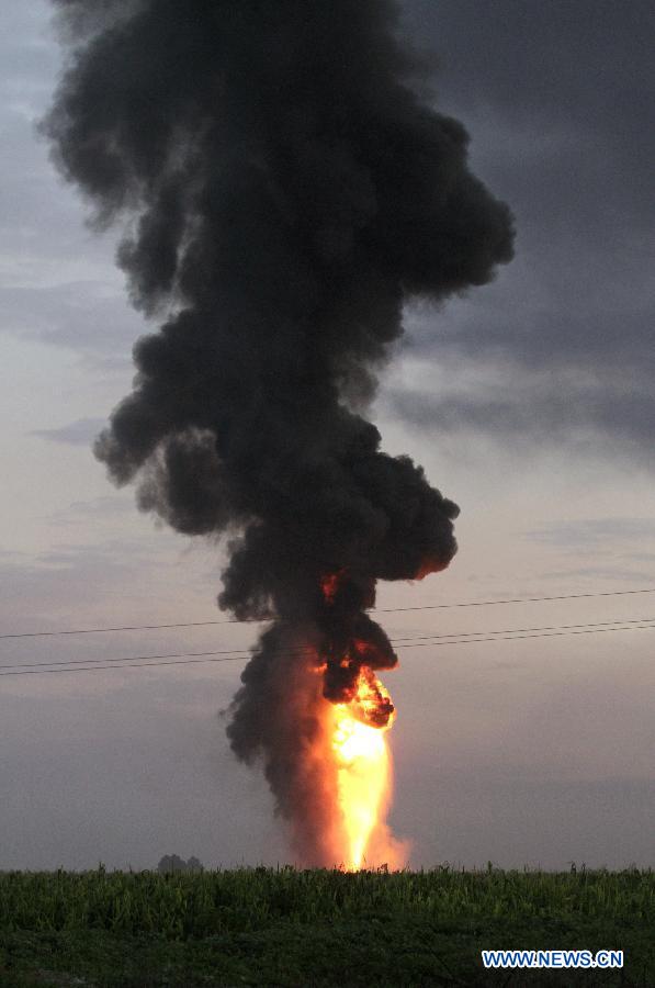 A fire plume rises in the place where a fire was registered in a duct of the Mexican oil company Pemex, in the Tonanitla municipality, in the State of Mexico, Mexico, on July 21, 2013. The oil spill and fire in Tonanitla were caused by a clandestine outlet to extract the fuel, Pemex confirmed in a statement. Until now, the authorities have reported 6 people wounded, two of them belonging to the fire brigade and four municipal policemen. (Xinhua/Juan Carlos Villa)