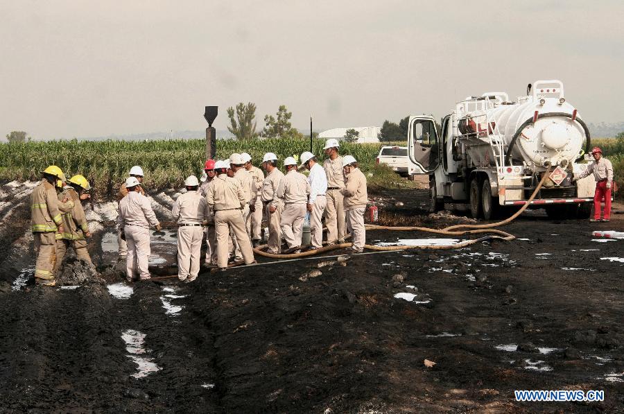 Firemen work near the place where a fire was registered in a duct of the Mexican oil company Pemex, in the Tonanitla municipality, in the State of Mexico, Mexico, on July 21, 2013. The oil spill and fire in Tonanitla were caused by a clandestine outlet to extract the fuel, Pemex confirmed in a statement. Until now, the authorities have reported 6 people wounded, two of them belonging to the fire brigade and four municipal policemen. (Xinhua/Juan Carlos Villa)