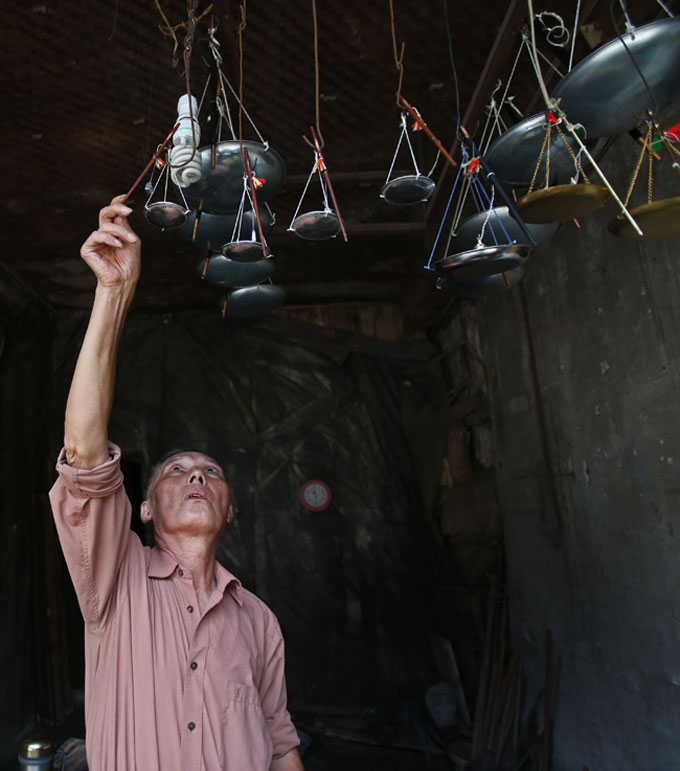 Lu hangs up the finished handmade scales on July 16, 2013 in Changsha, capital of central China's Hunan province. Lu, 74, has made scales for his lifetime. In Jinggang town, which was the major rice market of old Changsha, every household had handmade scales. Some old residents still get used to using the handmade scales. Lu is the only craftsman who still makes handmade scales in the old town. (Xinhua/Huang Xiaobang) 