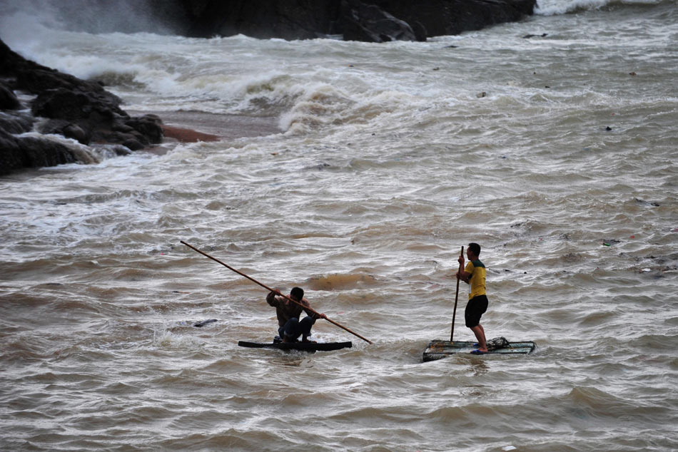 Two fishermen brave the storm waves to land on July, 13 2013, Lianjiang county of southeast China's Fujian province. Typhoon Soulik made a landfall in Fujian province on the Chinese mainland between at 4 p.m. that day. (Xinhua/Wei Peiquan)