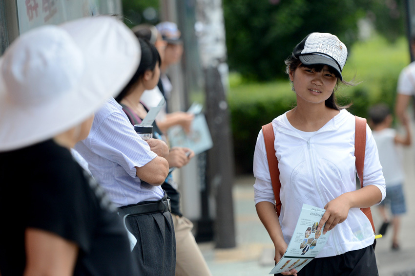 Liu Yi distributes leaflets on July 19.  (Xinhua/ Zhang Rui) 